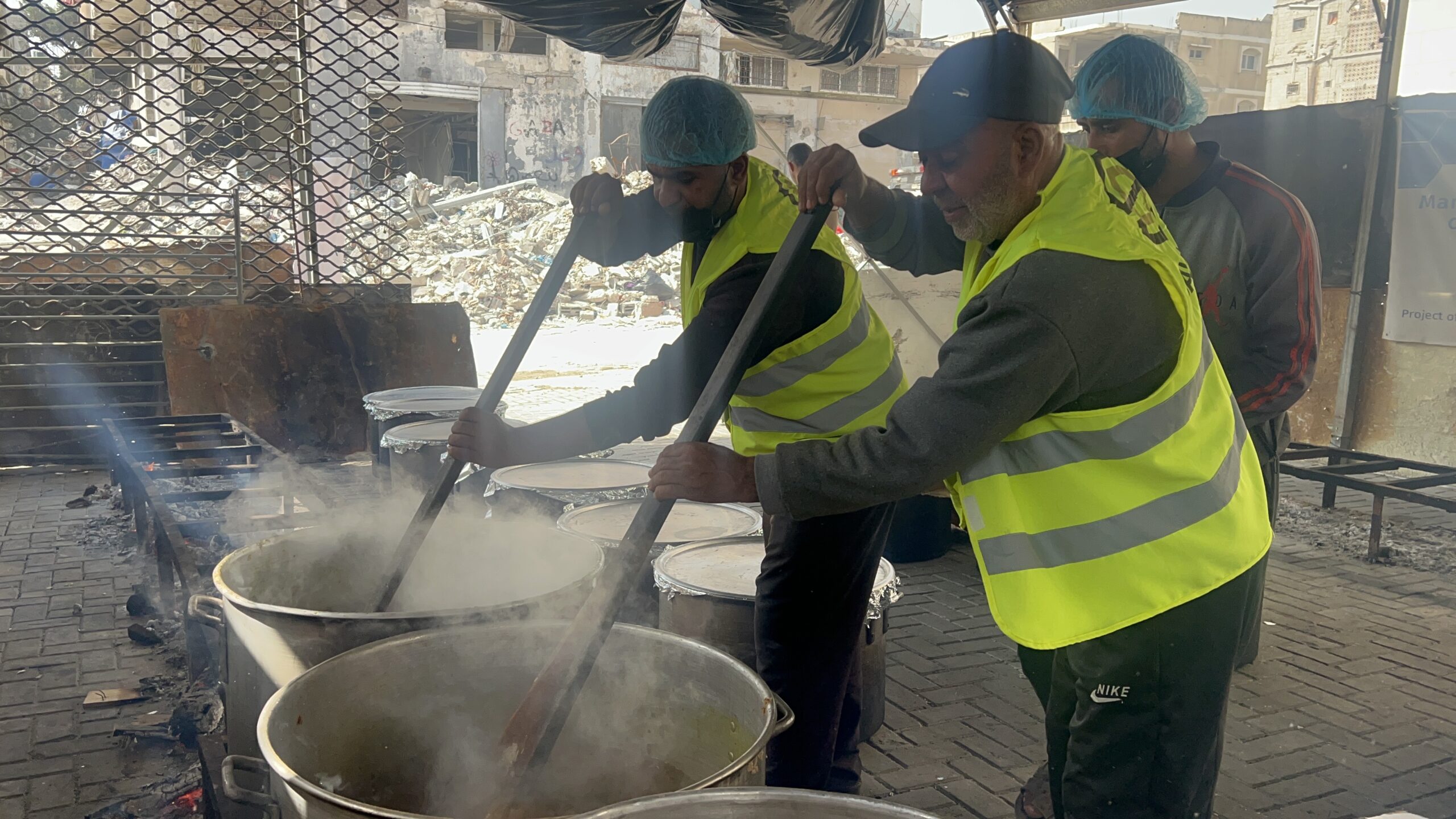 2 hommes préparant le repas bande de gaza pour offrir au jeûneurs parmi les démunis