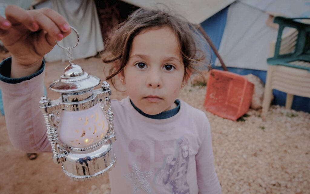 Petite fille des camps de réfugiés tenant un lanterne dans sa main pour le Ramadan