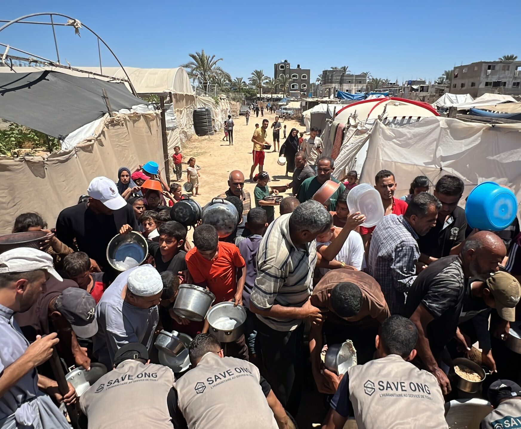 PERSONNES faisant la queue en attendant qu'on leur servent un repas par save ong à gaza